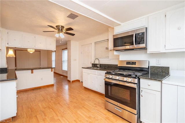 kitchen featuring sink, ceiling fan, appliances with stainless steel finishes, light hardwood / wood-style floors, and white cabinets