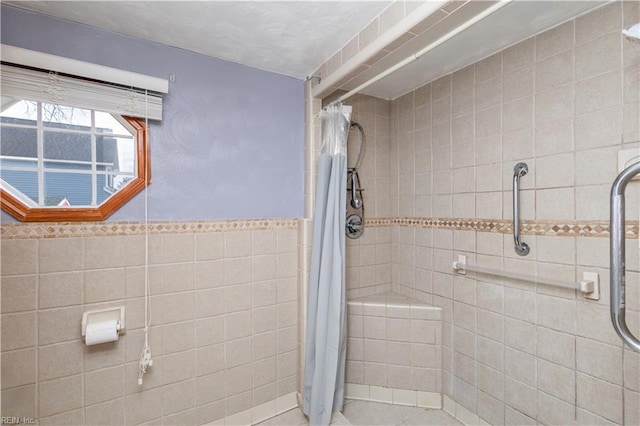 bathroom with curtained shower and tile walls