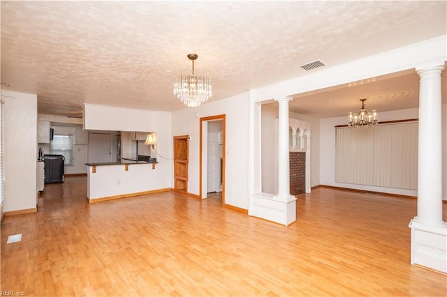 unfurnished living room with light hardwood / wood-style flooring and ornate columns