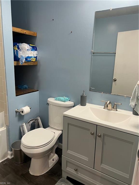 full bathroom with hardwood / wood-style flooring, vanity, shower / bathing tub combination, and toilet