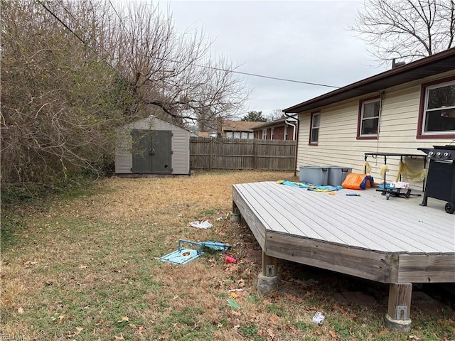 view of yard featuring a wooden deck and a storage shed