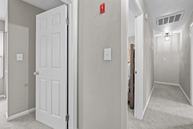 hallway featuring light colored carpet