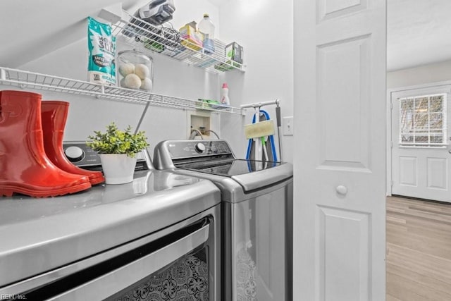 laundry area featuring light wood-type flooring and washer and clothes dryer