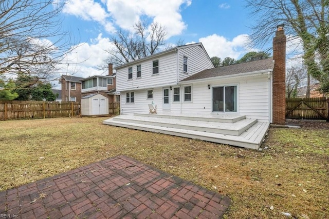 rear view of property with a storage shed, a yard, and a deck