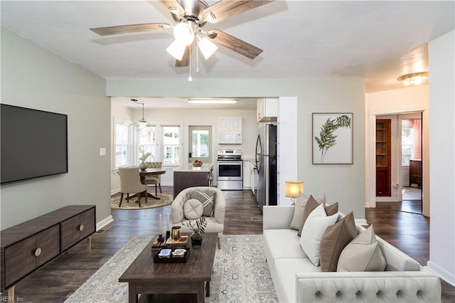 living room featuring ceiling fan and dark hardwood / wood-style floors