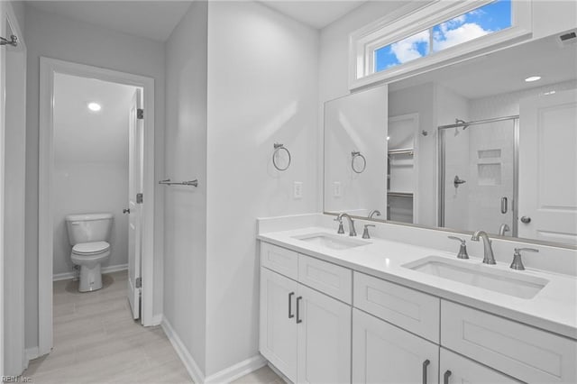 bathroom with walk in shower, vanity, and toilet