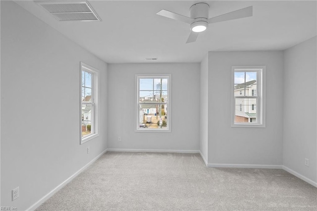 empty room with ceiling fan and light carpet