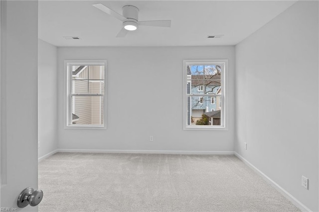 spare room with ceiling fan and light carpet