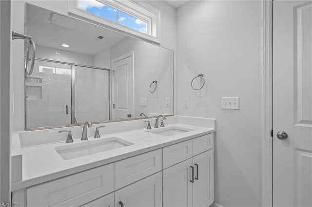 bathroom with vanity and a shower with door