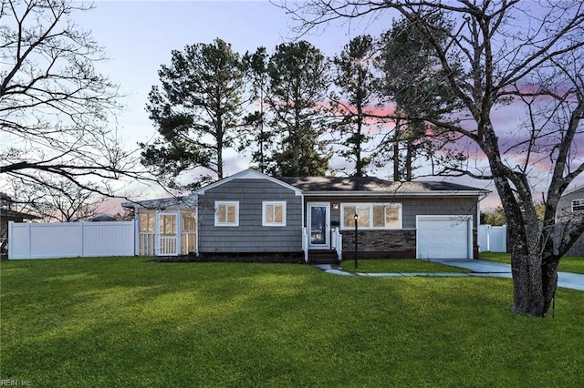 single story home with a garage and a lawn