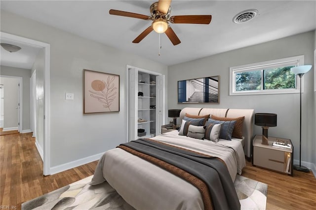 bedroom with ceiling fan, light wood-type flooring, and a closet