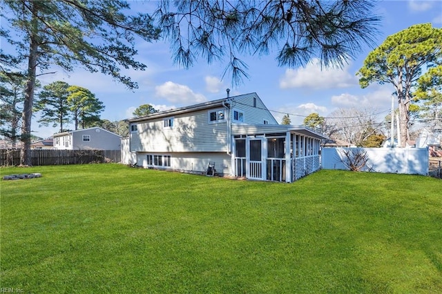 back of house with a sunroom and a lawn