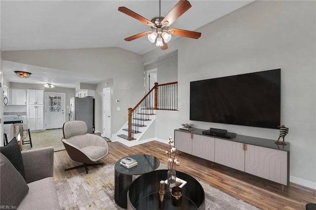 living room with ceiling fan, lofted ceiling, and light wood-type flooring