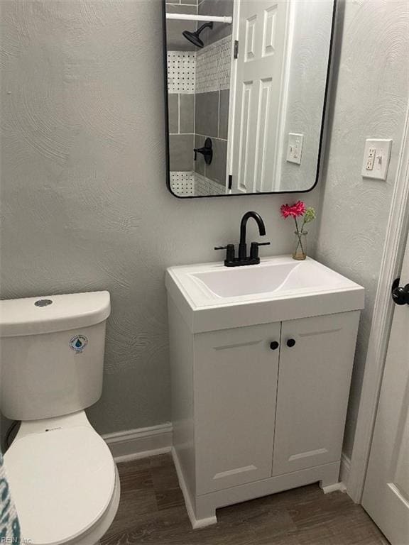 bathroom with hardwood / wood-style flooring, vanity, and toilet