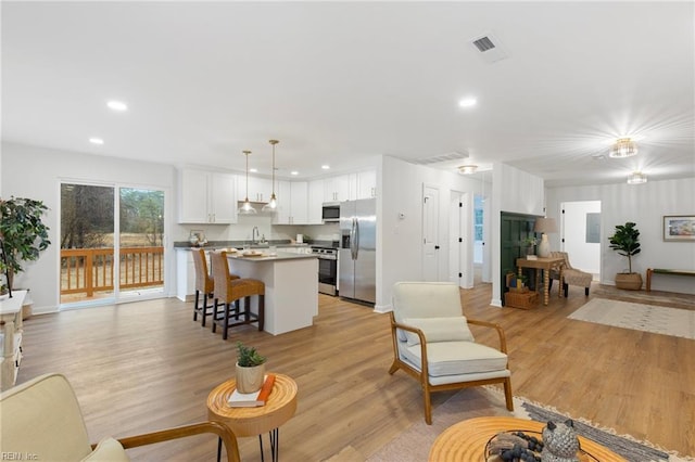 living room with sink and light hardwood / wood-style floors