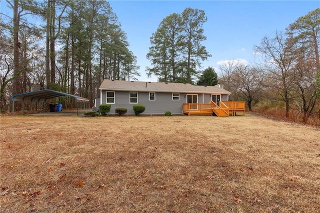 rear view of property with a wooden deck, a carport, and a yard