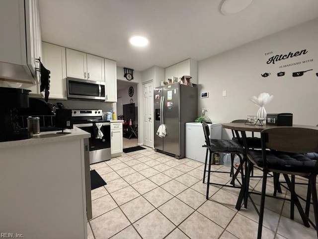 kitchen with white cabinetry, stainless steel appliances, and light tile patterned flooring