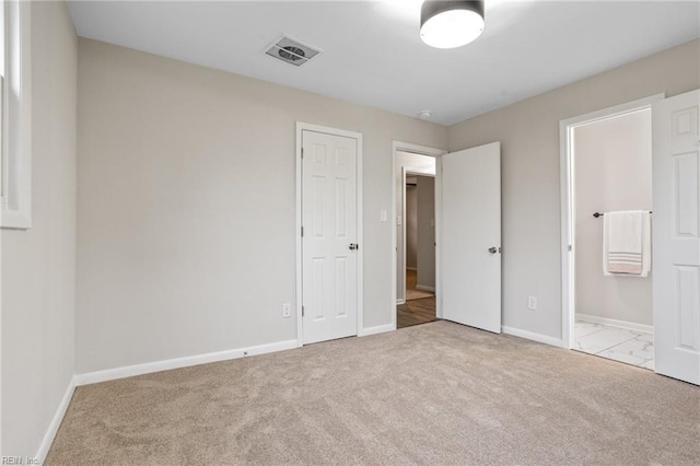 unfurnished bedroom featuring connected bathroom and light colored carpet