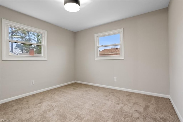 spare room featuring plenty of natural light and light carpet