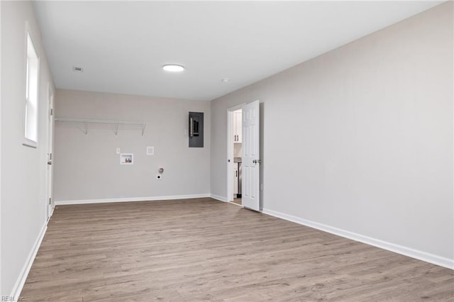 spare room featuring electric panel and light wood-type flooring