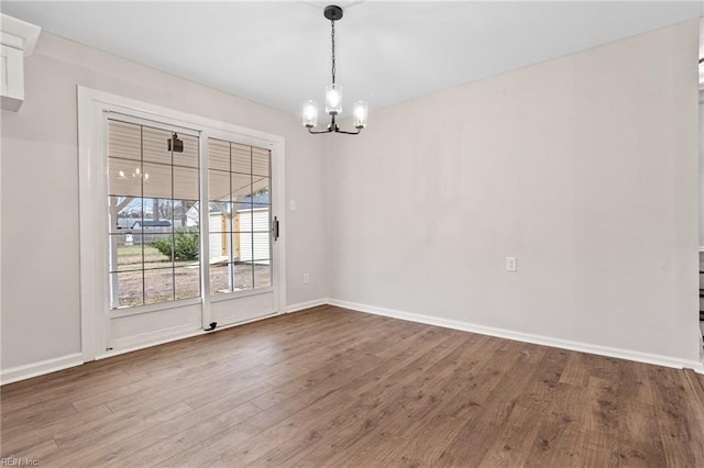 unfurnished dining area featuring hardwood / wood-style flooring and a chandelier