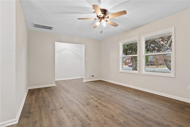 empty room with dark wood-type flooring and ceiling fan