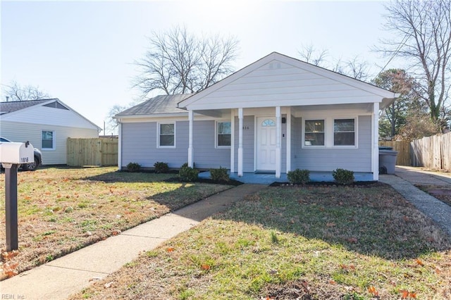 ranch-style house with a front yard and covered porch