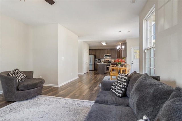 living room featuring dark hardwood / wood-style flooring and an inviting chandelier