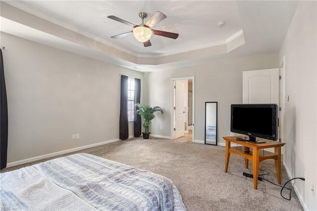 carpeted bedroom with a tray ceiling, ornamental molding, and ceiling fan