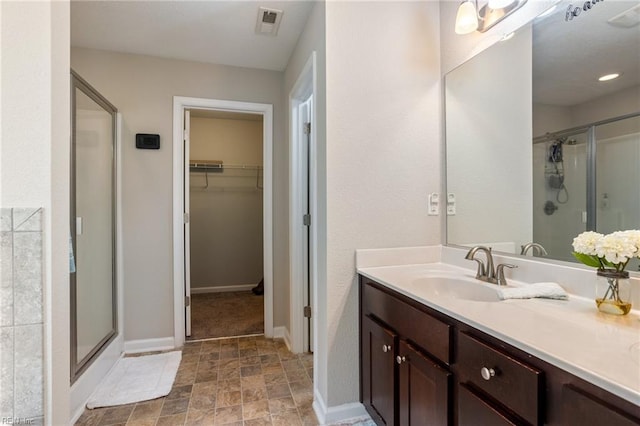 bathroom with a shower with door and vanity