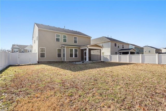 rear view of house featuring a lawn