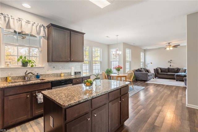 kitchen featuring dark wood-type flooring, sink, a center island, dark brown cabinets, and hanging light fixtures