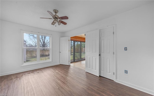 empty room with ceiling fan and dark hardwood / wood-style flooring