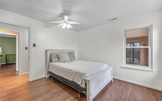 bedroom with dark hardwood / wood-style flooring and ceiling fan