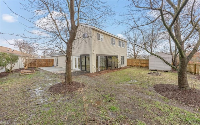 rear view of property with a patio, a yard, and a shed