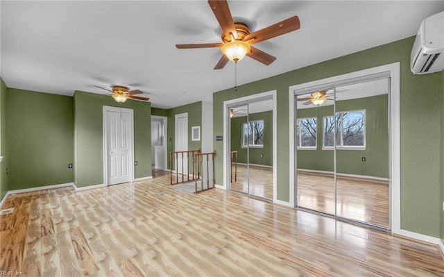 empty room with a wall mounted air conditioner and light wood-type flooring