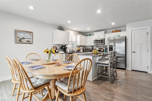 dining area with dark hardwood / wood-style floors and sink