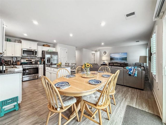 dining area with sink and light hardwood / wood-style flooring