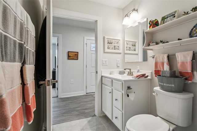 bathroom featuring tile patterned flooring, vanity, and toilet