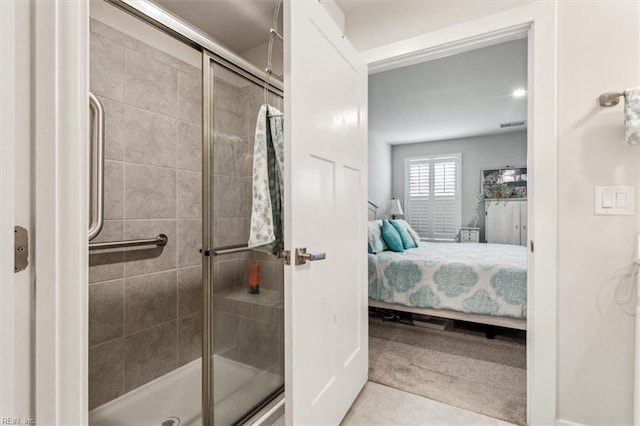 bathroom featuring a shower with shower door and tile patterned floors