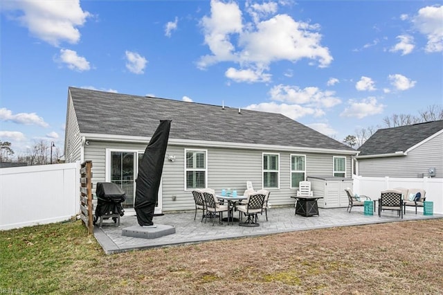 rear view of house with a yard, a hot tub, and a patio area