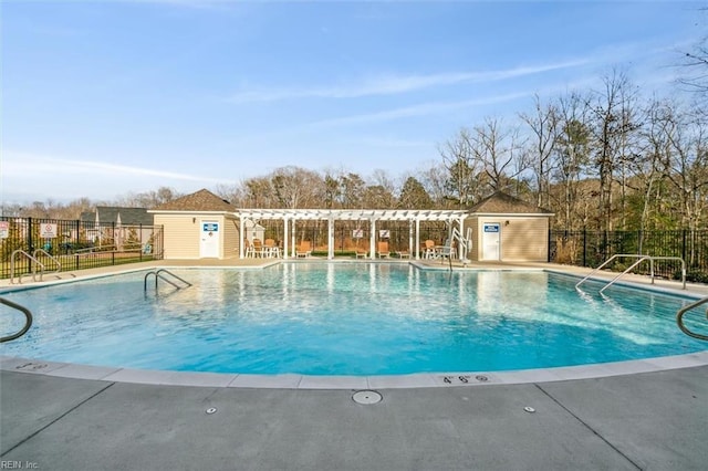 view of pool featuring an outbuilding, a patio area, and a pergola