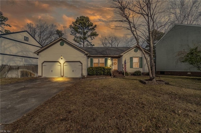 view of front of house with a garage and a yard