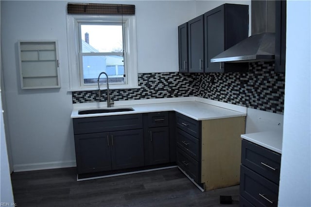 kitchen with backsplash, gray cabinets, sink, and wall chimney range hood