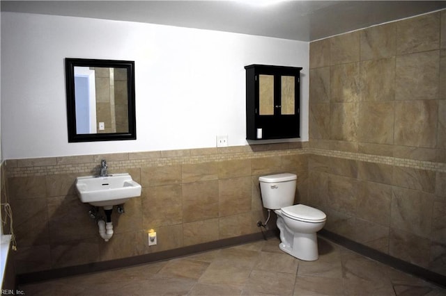 bathroom with tile walls, sink, tile patterned floors, and toilet