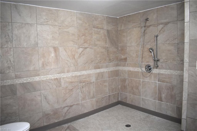 bathroom with tiled shower and toilet