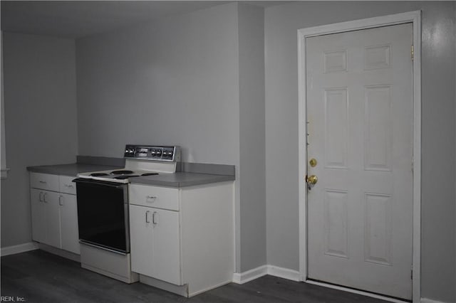 kitchen featuring electric range, dark wood-type flooring, and white cabinets