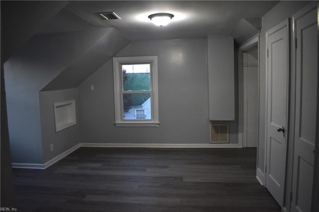 bonus room with dark wood-type flooring and lofted ceiling