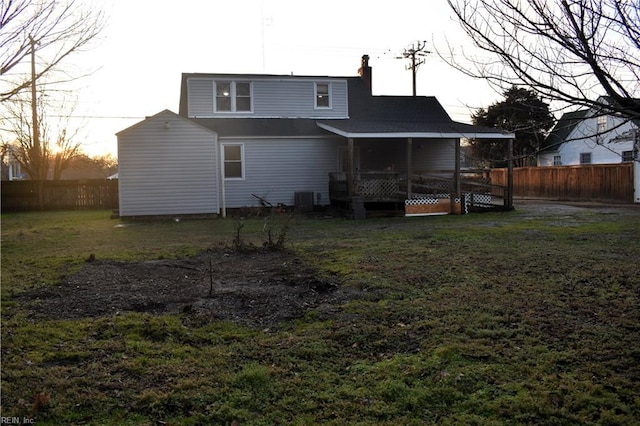 back of property with cooling unit and a lawn