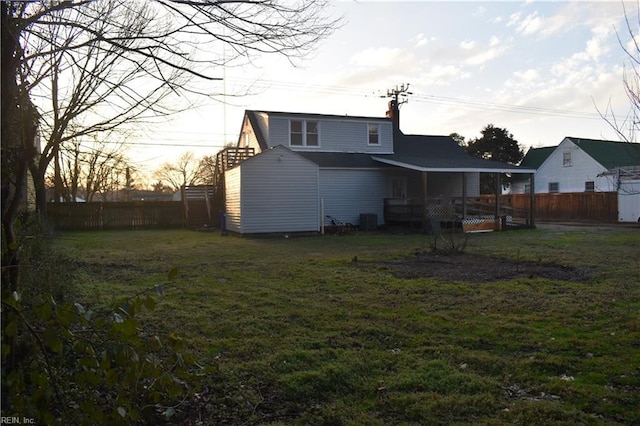 rear view of property featuring a yard and central air condition unit